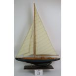 A decorative wooden single masted pond yacht on plinth.