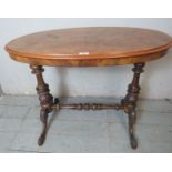 A Victorian oval hall table with a quarter veneered walnut top over an ornately carved mahogany