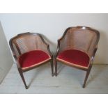 A pair of Edwardian mahogany his & her's bergere tub chairs, boxwood strung with parquetry inlay,