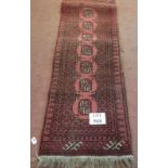 A 20th Century Persian rug on claret ground. 140cm x 52cm.