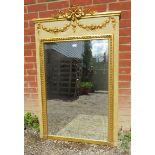 A large ornate gilt rectangular bevelled wall mirror with moulded gilt surround and applied gilt