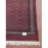 A 20th Century Bakarah rug on claret ground. 194cm x 123cm.