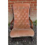 A Regency button back mahogany framed rocking chair with scrolled arms,