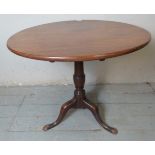 A late Georgian oak circular tilt top occasional/wine table, raised on a turned column,