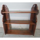 An antique oak wall hanging bookshelf with carved openwork side detailing.