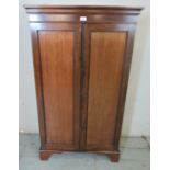An Edwardian mahogany enclosed bookcase, the twin doors with inset fielded panels,