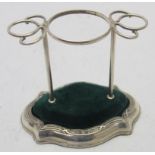 A silver hatpin stand, the base with cro