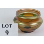 A Louis Comfort Tiffany Favrile glass bowl with green tracery pattern and gold opalescent finish.