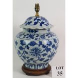 A 20th Century blue and white porcelain jar lamp hand decorated with floral motifs. Height: 44cm.