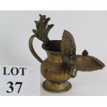 A small brass antique Himalayan Hindu temple votive lamp featuring an image of Ganesha above the