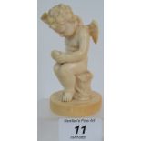 A late 19th/early 20th Century romantic figure of Cupid mending a broken heart intricately carved