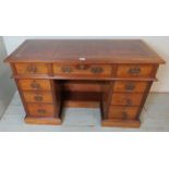 A turn of the century mahogany ladies kneehole desk with an inset gilt brown leather writing