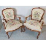A pair of vintage oak framed open sided French armchairs upholstered in a floral patterned tapestry