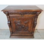 A late Victorian oak cabinet ornately carved in the Flemish taste with lion's mask & figureheads,
