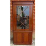 An Edwardian mahogany barrel backed hall corner cupboard with 13 pane astral glazed door opening