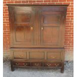 A Georgian oak housekeeper's cupboard the twin doors opening onto a hanging rail and chunky wooden