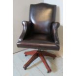 A good quality swivel reclining & height adjustable antique style desk chair upholstered in a dark