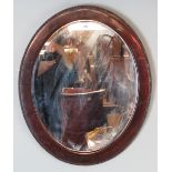 An antique oval rosewood framed bevelled