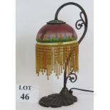 An Art Nouveau style table lamp with glass shade hand decorated with Tiffany style dragonflies.