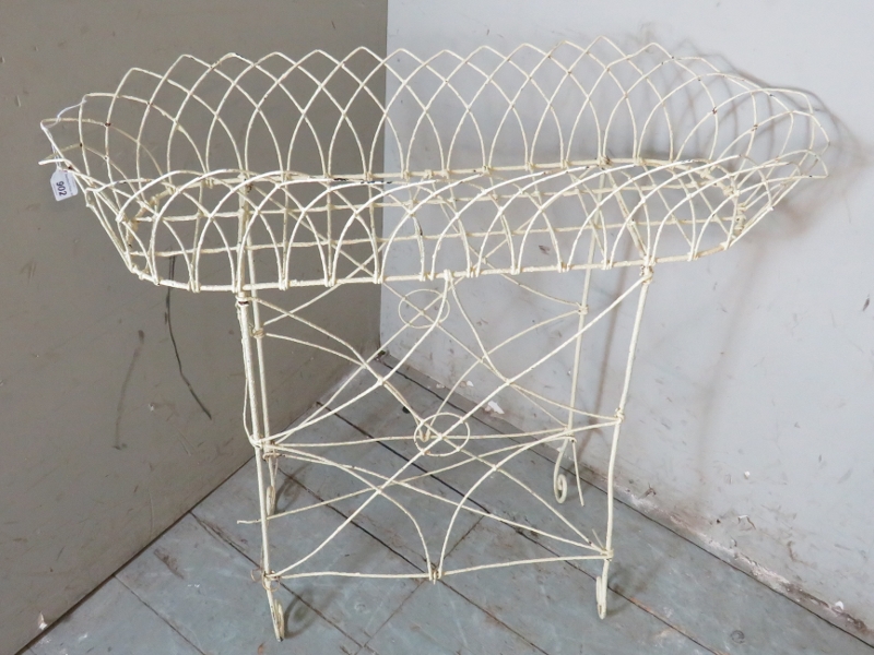 A vintage bent wire white metal trough planter on stand, raised on scroll feet.