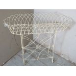 A vintage bent wire white metal trough planter on stand, raised on scroll feet.