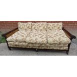 A Victorian mahogany framed three seater bergere sofa with acanthus carved and scrolled armrests