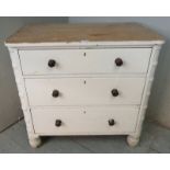 A 19th century painted pine chest of three long drawers with turned wooden knob handles, raised on