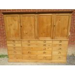 A very large antique pine linen press, the top section with two pairs of double doors enclosing