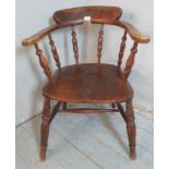 A 19th century elm desk chair with spindle turned uprights raised on baluster turned supports united