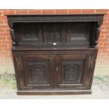 An 18th century oak court cupboard of small proportions with carved frieze over two cupboard doors