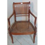 An Edwardian Regency revival mahogany elbow chair with bergere seat, raised on sabre legs. 90cm high