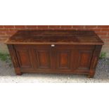 An early 18th century oak coffer with twin candelabras and marquetry inlaid fielded panels to front,