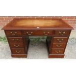 An Edwardian mahogany pedestal desk with inset tan leather tooled writing surface over a
