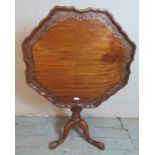 A 19th century mahogany tilt top table with pie crust edge carved with acanthus leaves, raised on