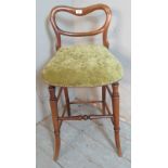 A Victorian rosewood cellist's stool with a low back over a downward sloping seat, upholstered in