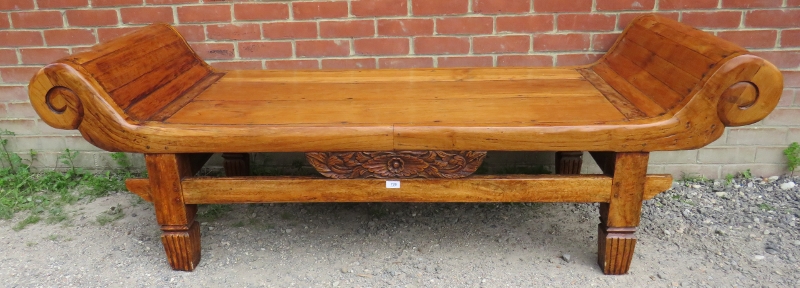 A Chinese hardwood opium table with scrolled ends and carved frieze decoration, raised on tapering