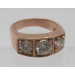 A 9ct rose gold three stone diamond gypsy ring set with 1.76 ct round brilliant cut diamonds, centre