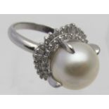 A large platinum Art Deco style white Southsea pearl ring with a round cut & baguette diamond,