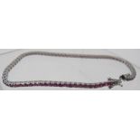 An 18ct white gold ruby line bracelet with open work clasp and double safety catch, rubies approx