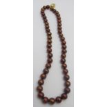 A freshwater chocolate coloured pearl necklace with a 9ct gold coffee bean shaped clasp,