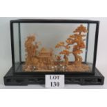 A Chinese carved cork diorama of a traditional pagoda scene in a glazed black lacquered case and