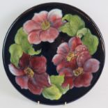 A Moorcroft pottery charger decorated with clematis pattern c1955, bearing incised and painted marks