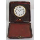 An early 20th Century Army and Navy Stores Swiss fob travel clock in folding leather case, the