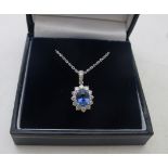 An 18ct white gold oval cut sapphire and round brilliant cut diamond cluster pendant, with diamond