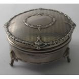 A silver circular trinket/ring box with engraved decoration and fleur de lis feet, Birmingham