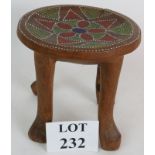 A four legged carved wood ethnic stool with dot painted seat, probably Australian. Height 23cm,