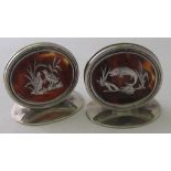 A pair of silver and tortoiseshell menu holders, one depicting fish, the other game birds,