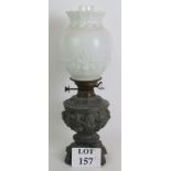 A highly ornate pewter based antique oil lamp with case Rococo cherubs and leopard heads with a