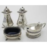 A pair of silver peppers, Birmingham 1912, a silver salt with blue liner, Birmingham 1953, and a