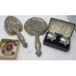 An Art Nouveau silver hand mirror heavily embossed with flowers, Chester 1909, and a matching hair